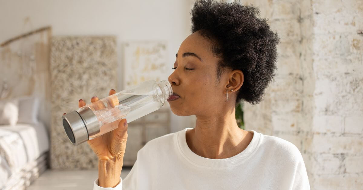 woman drinking from water bottle